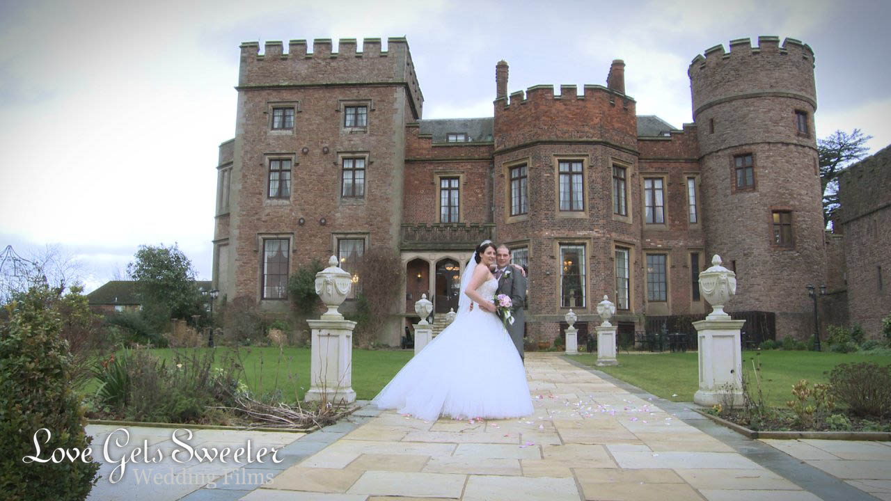 A couple stand in front of Rowton Castle for photographer and videographer