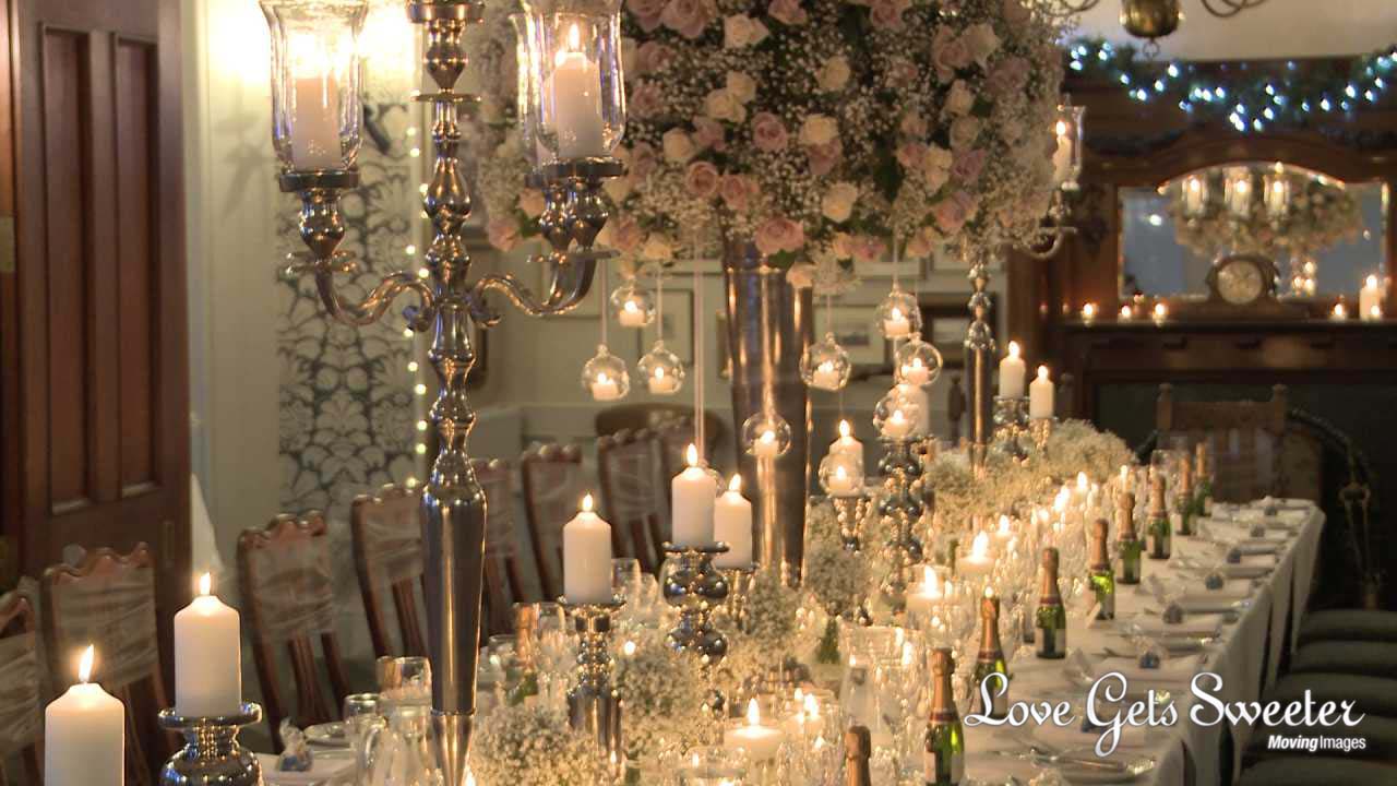 a stunning and romantic winter wedding breakfast table at Broadoaks country house hotel. The table is full of candles and towering white and blush rose centrepieces by Red Floral