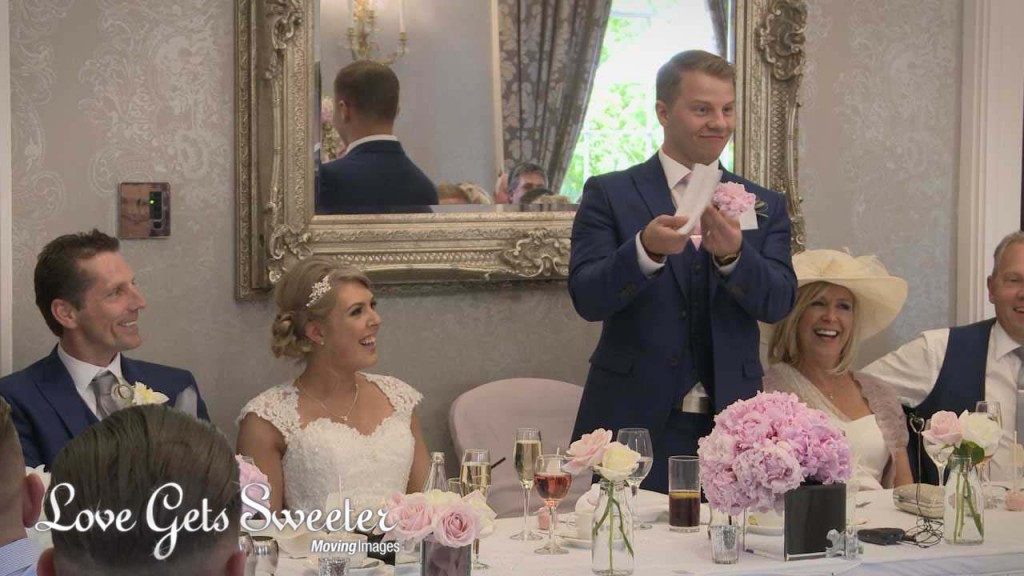 A wedding video still from the grooms speech at Oulton Hall in Leeds. He makes the top table laugh by showing off his queue cards