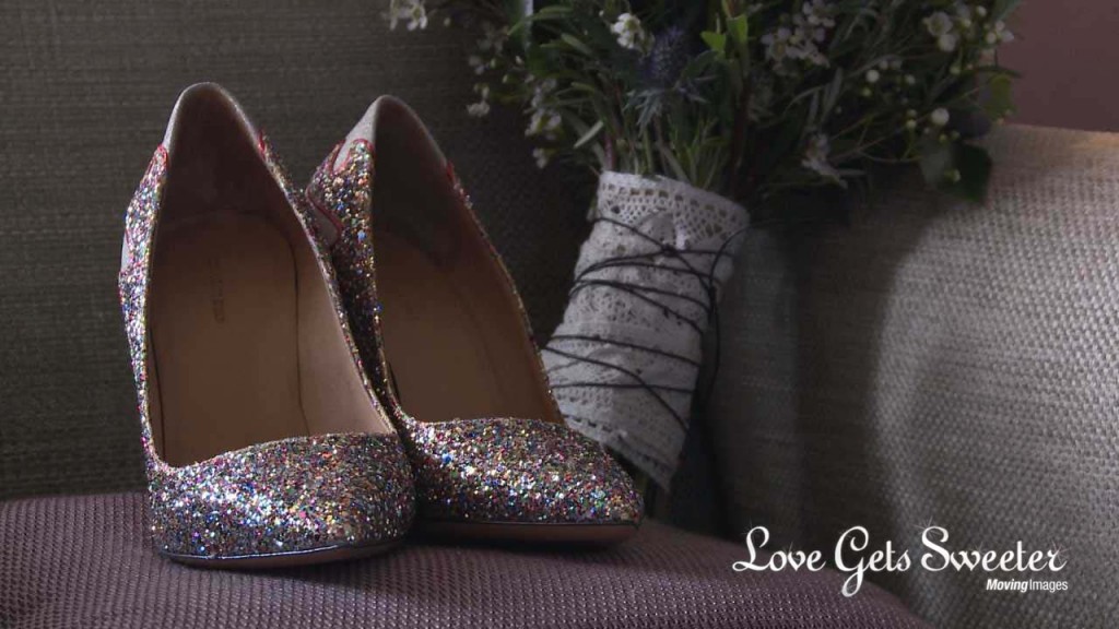Colourful and bright glitter wedding bridal shoes sit next to a hand tied bouquet wrapped in lace and string at Rookery Hall in Cheshire