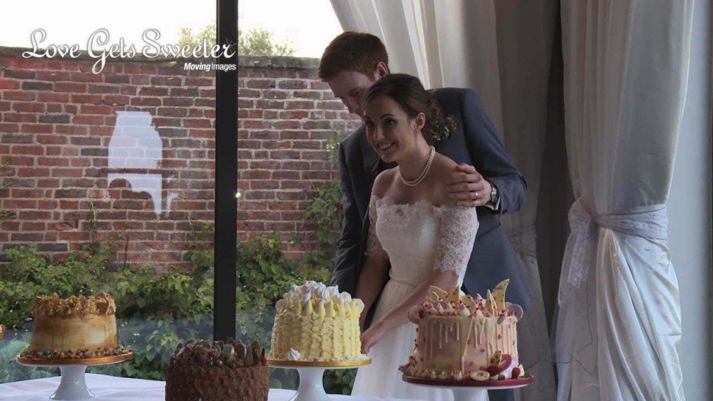 the bride and groom cut in to one of their 4 cakes from Cake O Rama in Manchester as they celebrate their wedding at Rookery Hall