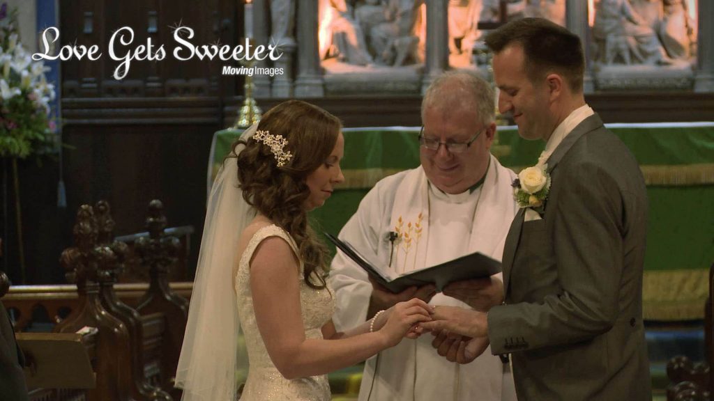 bride putting ring on groom and exchanging wedding vows during their church service in Cheshire