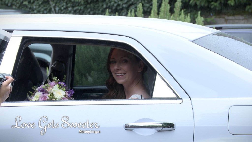 bride sat in her wedding car in the rain typical august wedding weather