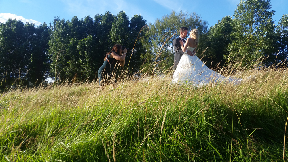 videographer photographer team filming bride and groom at outdoors wedding