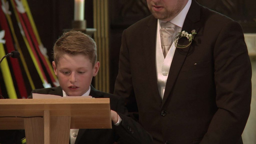 page boy doing a reading in the church for the bride and groom and recorded for their wedding video