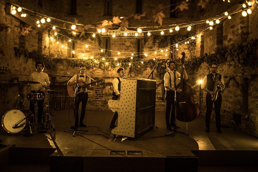performing for the video wandering wings are in a rustic barn with festoon lights giving a warm glow