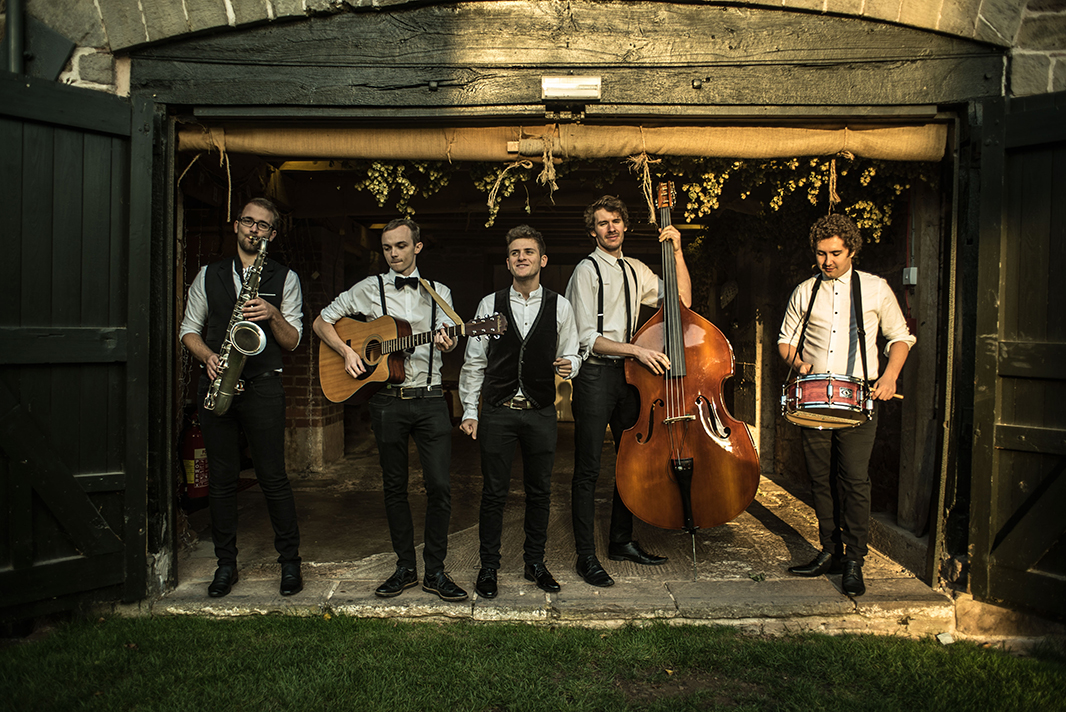 wandering wings promotional photographs outside a rustic barn with their instruments