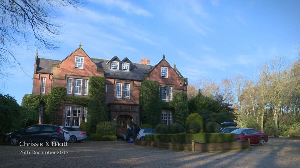The front of a stunning country house hotel wedding venue called Nunsmere Hall in the low winter light before a Christmas wedding on Boxing Day with a bright blue sky