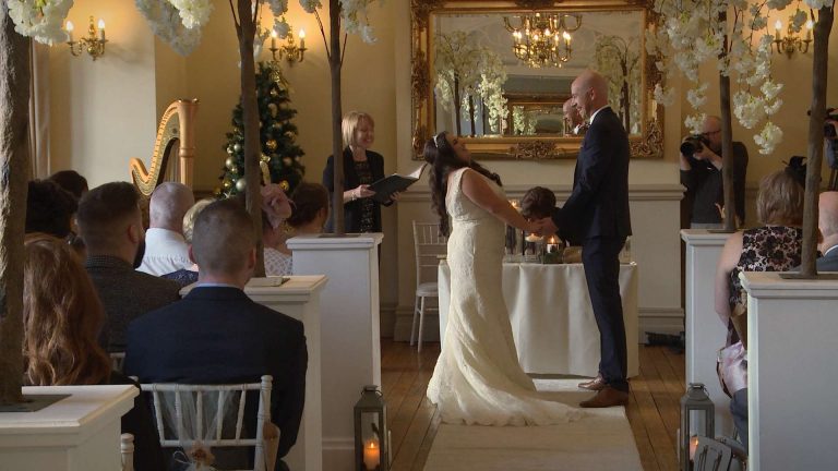 The bride throws her head back and laughs at the Groom during their fun and intimate wedding ceremony at Nunsmere Hall