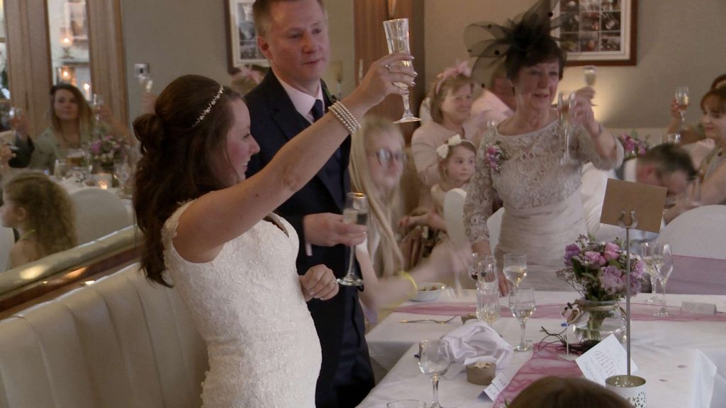 the bride raises her champagne glass to toast her wedding guests during speeches at the wordsworth hotel