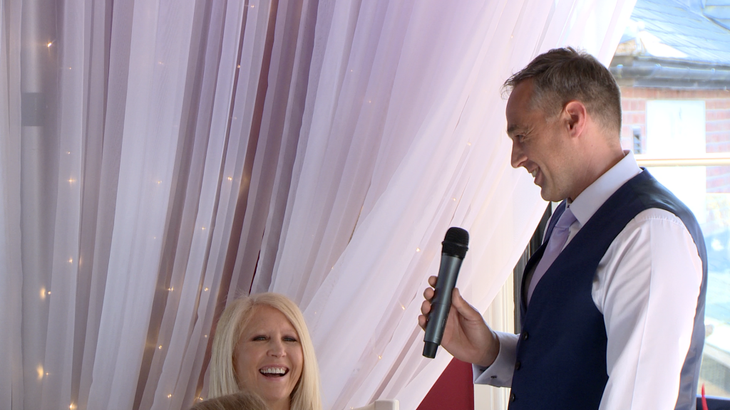 a wedding video still of the father of the bride making his wife laugh during his speech at the Blue Mallard in Burscough lancashire