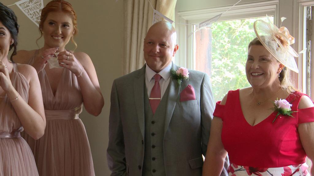 the dad and bridesmaids get emotional seeing the bride walk in in her wedding dress