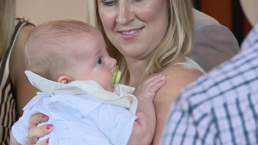 a close up of mum holding her baby boy Archie at st pauls of the cross in Burtonwood for his christening