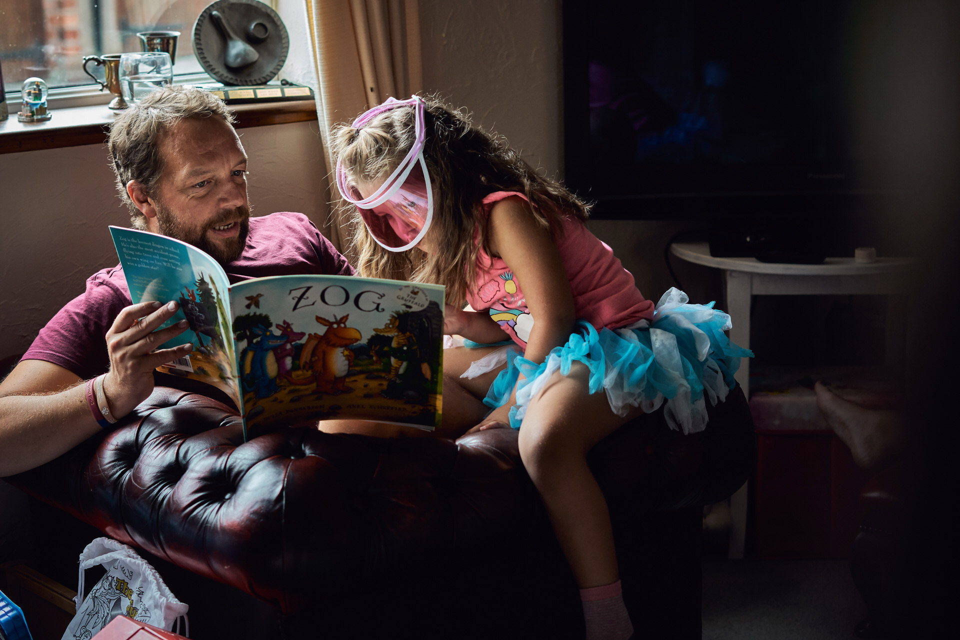 dad reads with daughter at home during candid family photoshoot