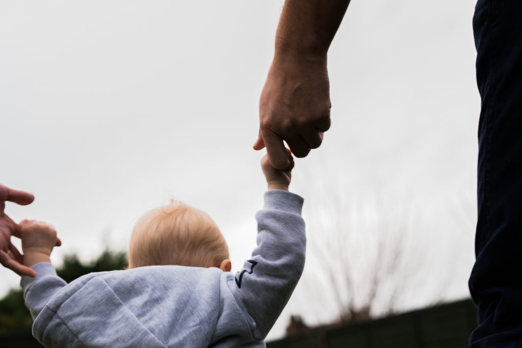 a close up of a girl holding her Dads hand during a outdoor family photoshoot near manchester