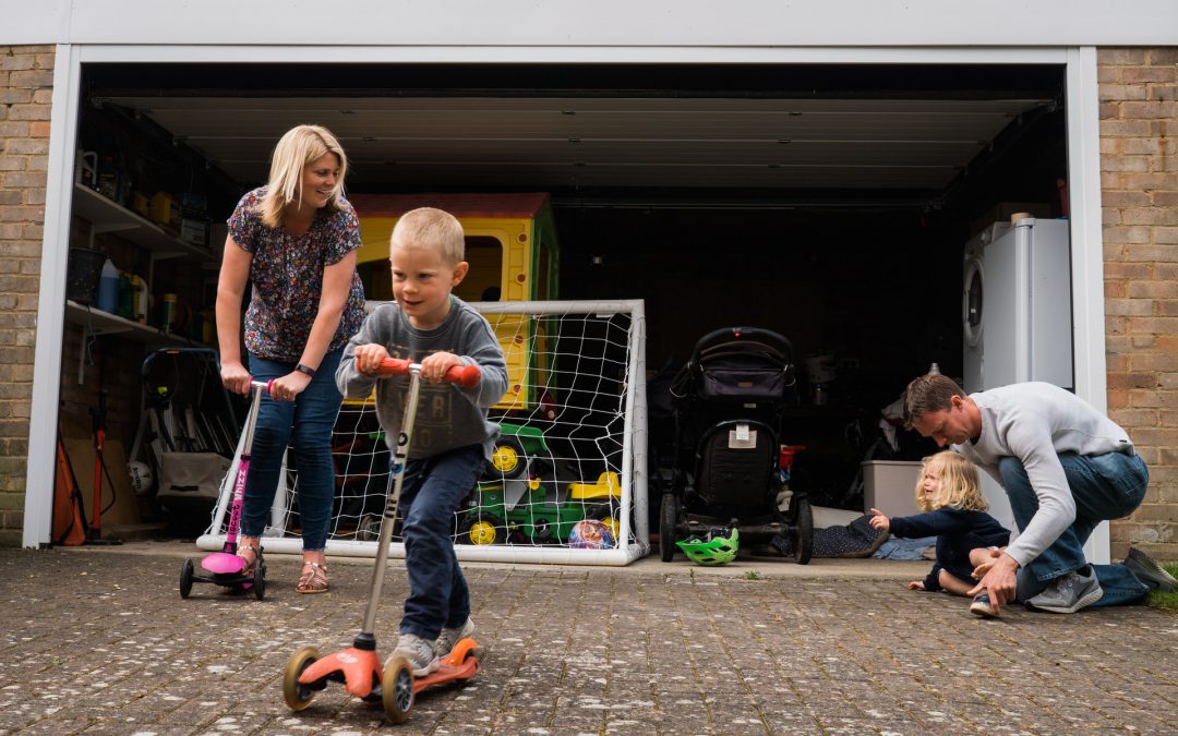 reportage style photograph of a family racing on scooters outside their home yorkshire