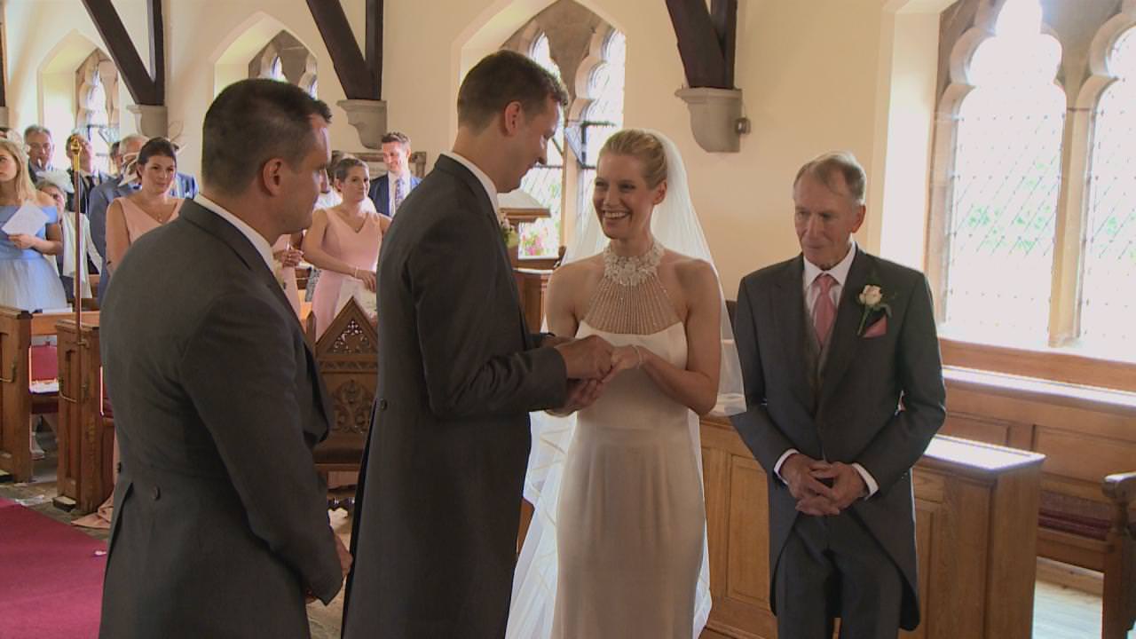 the bride and groom giggle exchanging wedding rings at a wedding in cheshire