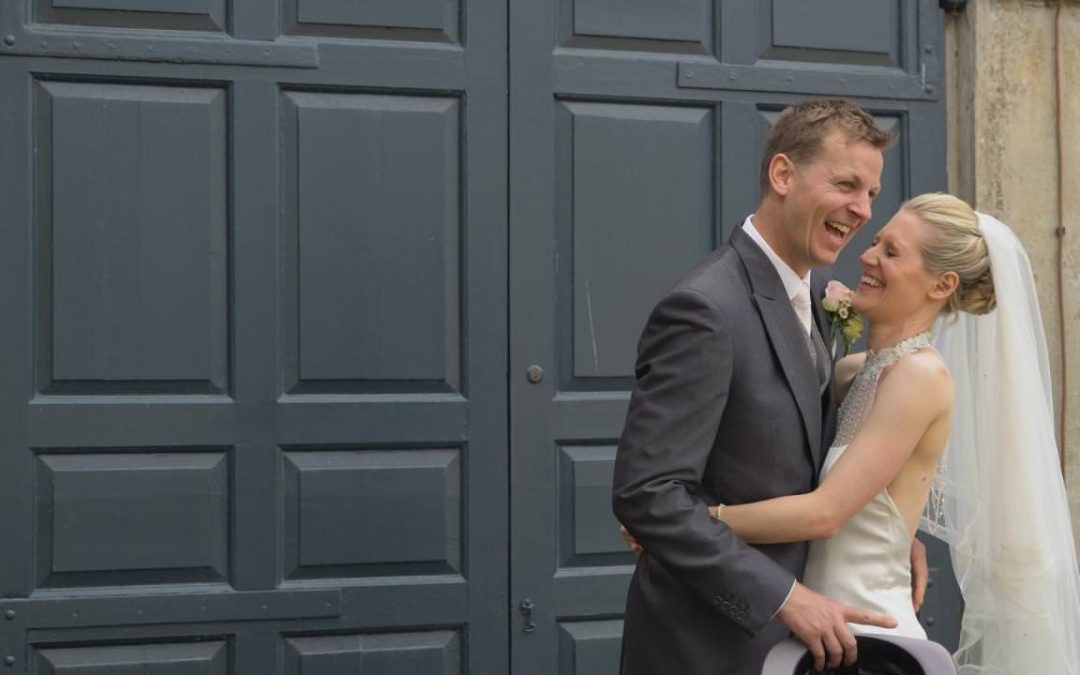 a bride and groom laugh during photos at Dunham Massey