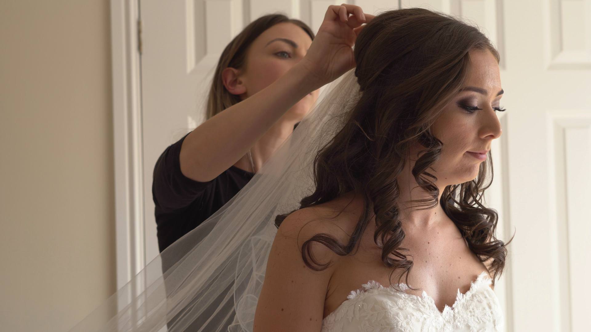 a make up artist add the brides veil before she heads to church