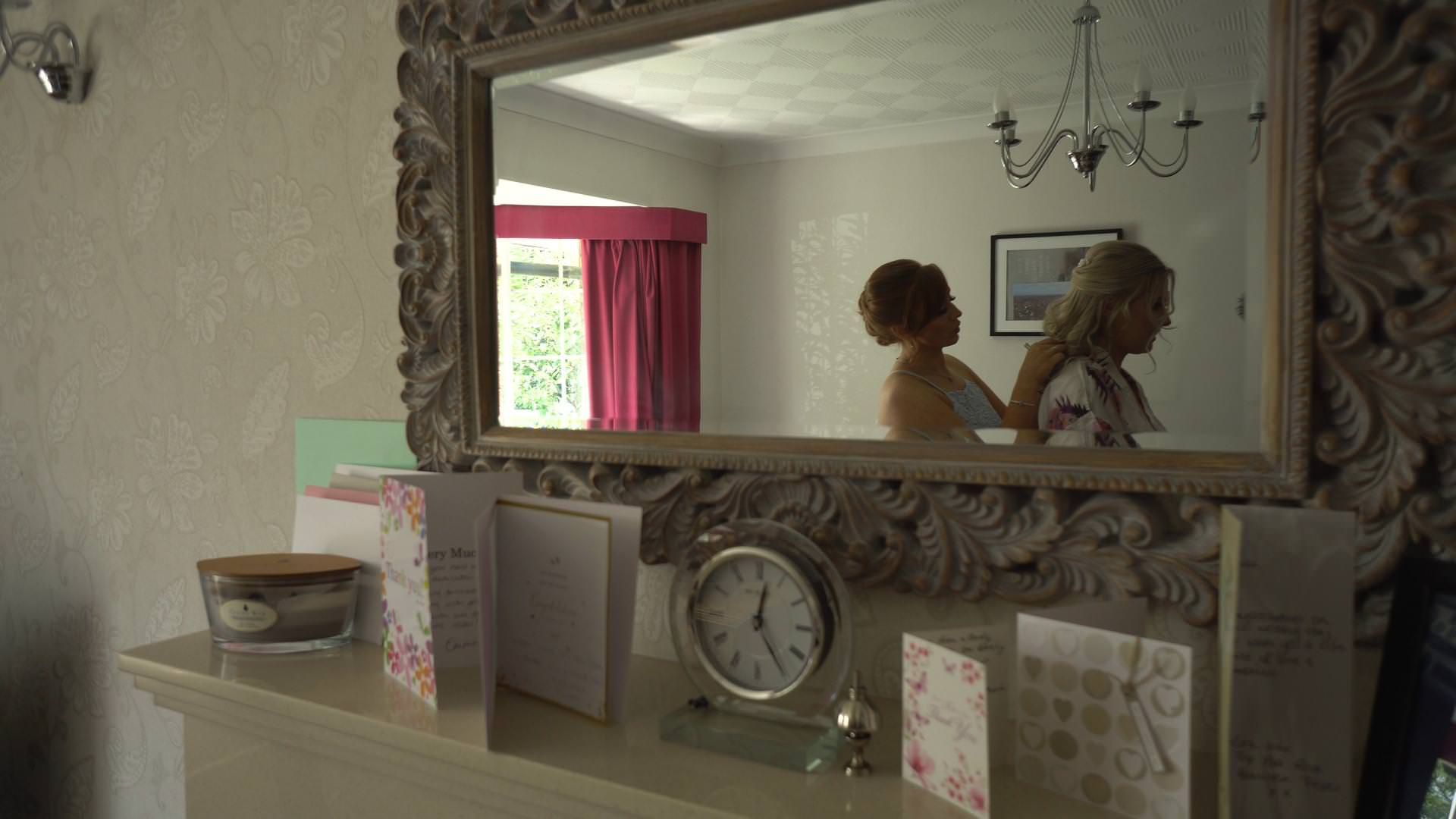 a video still of a mirror reflection of a bride getting ready at home in Newburgh
