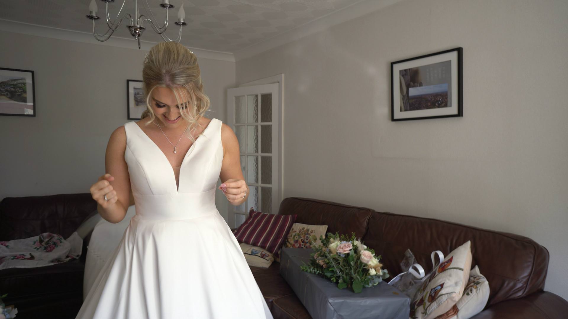 a bride stands in her classic silk wedding dress with pockets before her wedding in Burscough