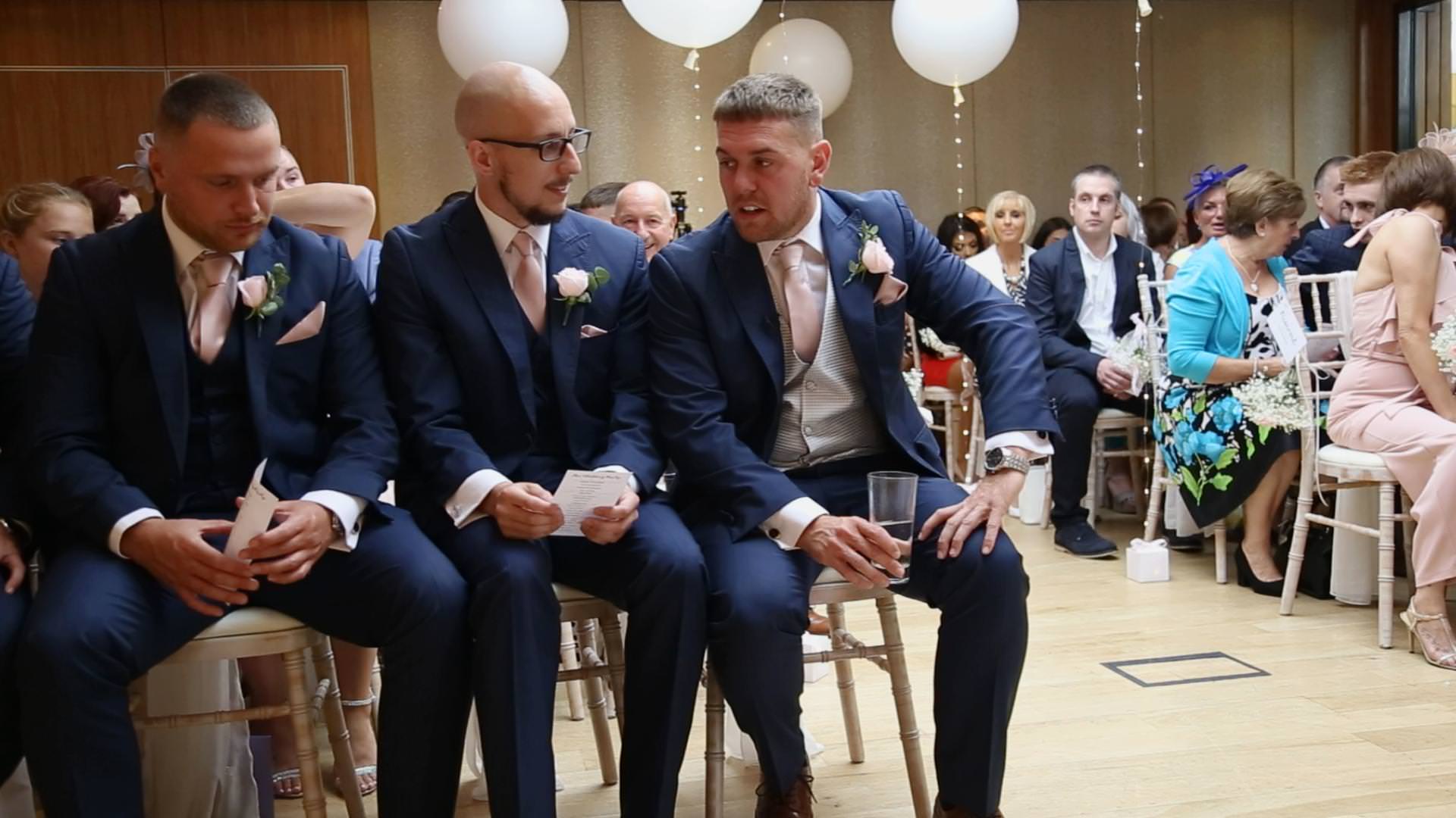 a groom and best man sit front row at a wedding indoor ceremony at Moddershall Oaks