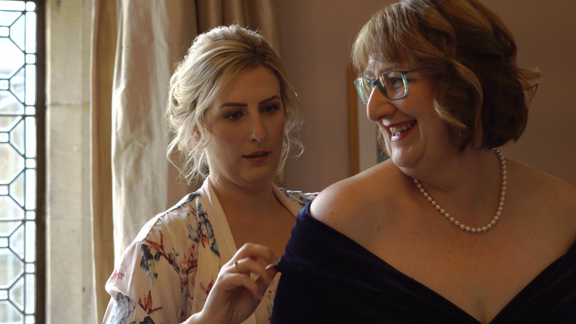 a bride helps her Mum in her dress