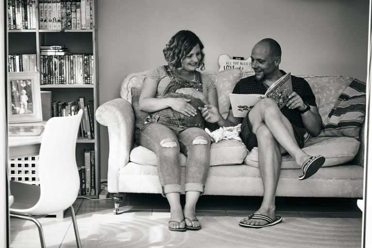 photo of couple reading to baby bump