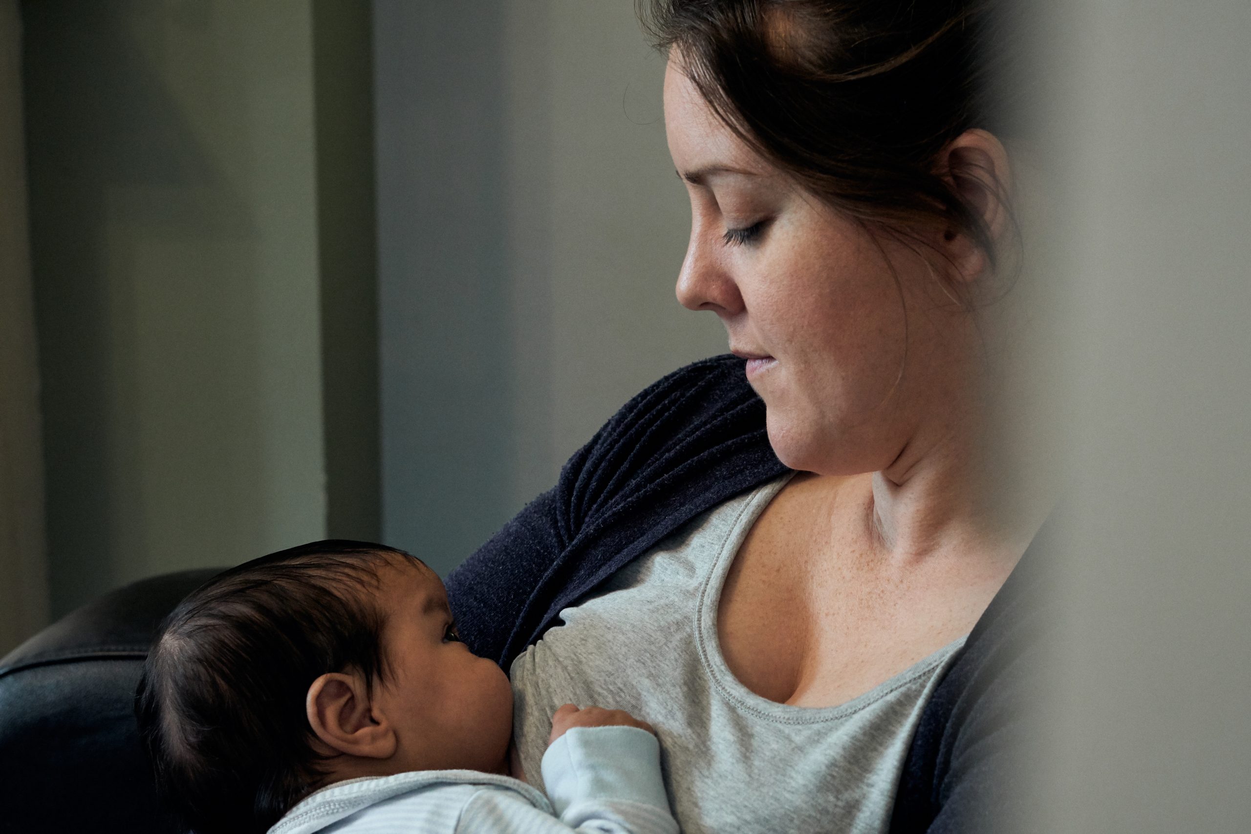Mum looks down at baby breastfeeding in Lancashire