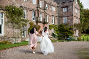 lottie brides helps bride with dress during shoot