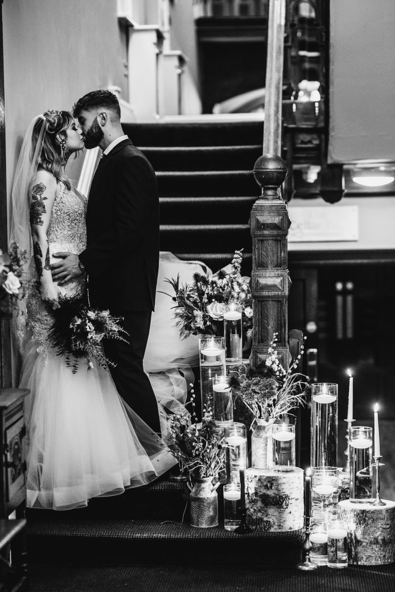 bride and groom kiss on stairs at west tower wedding venue