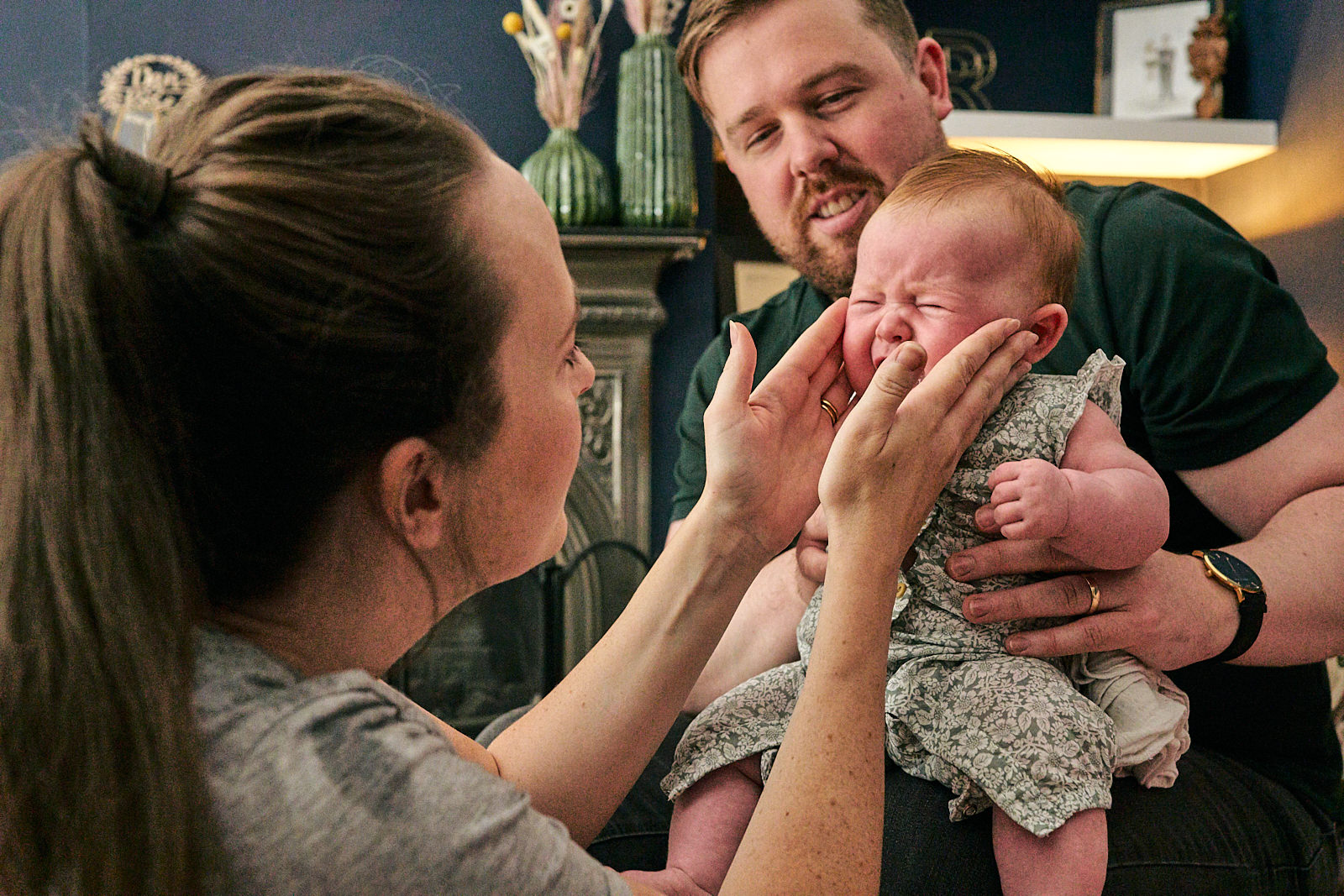 parents try to calm crying baby down for photoshoot