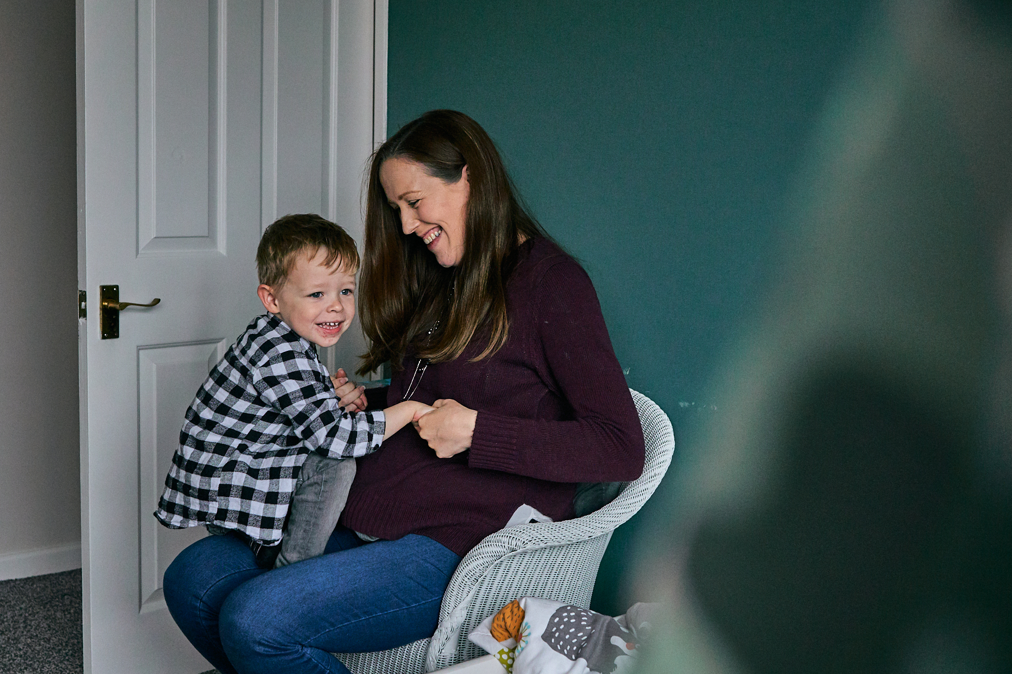 mum and son laugh together during bump photoshoot at home