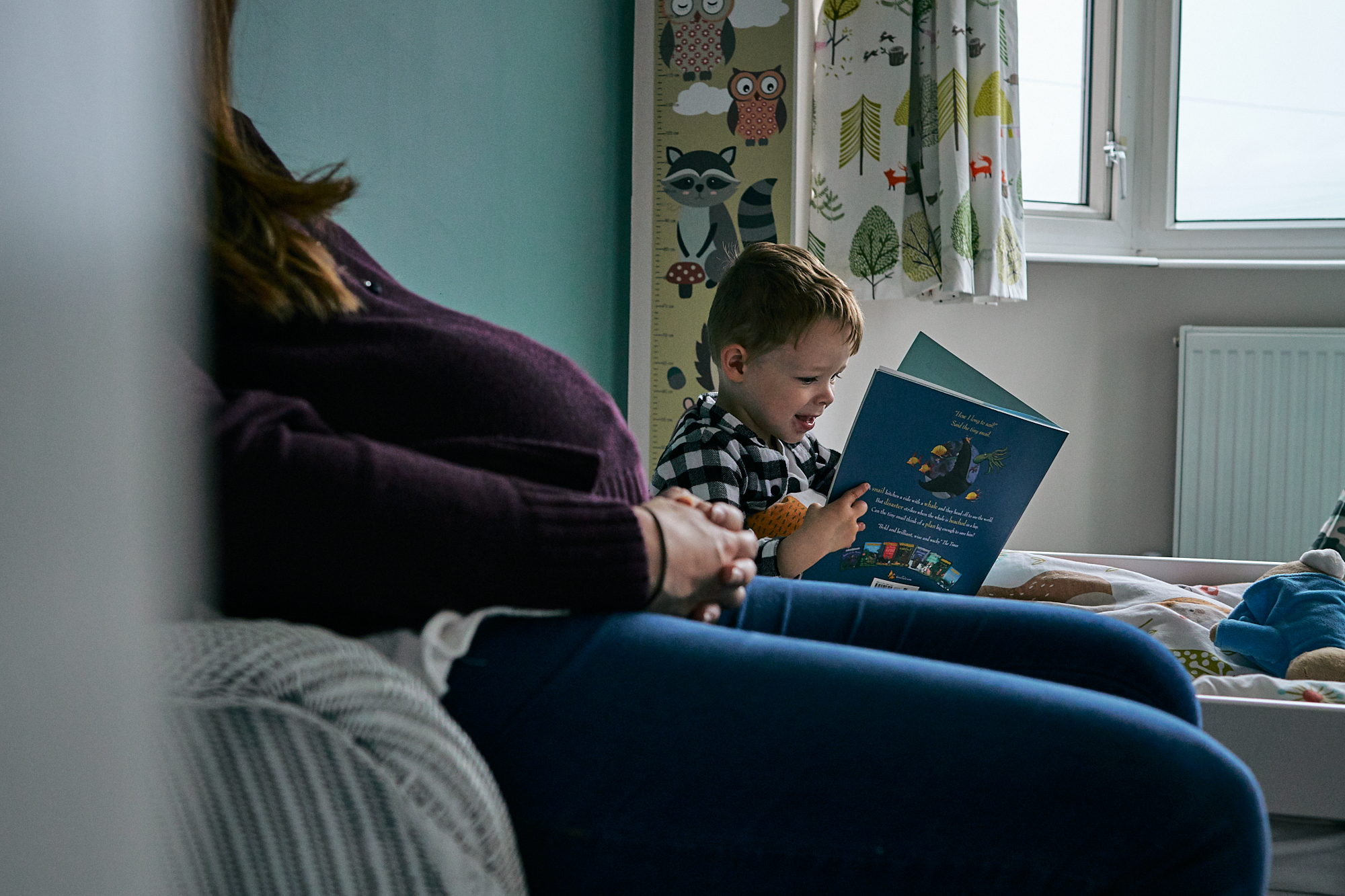 natural family photograph of boy reading to bump