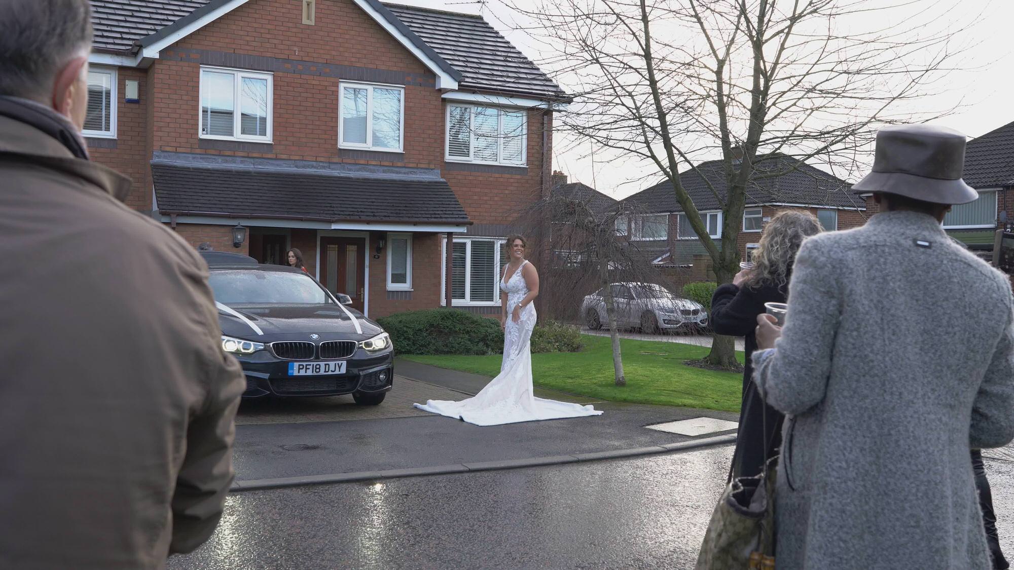 bride stands outside preston home to show dress to neighbours