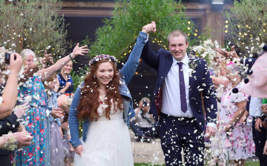 bride and groom smile during confetti cheshire woodland wedding