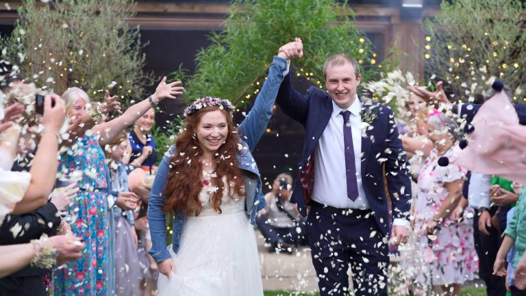 bride and groom smile during confetti cheshire woodland wedding