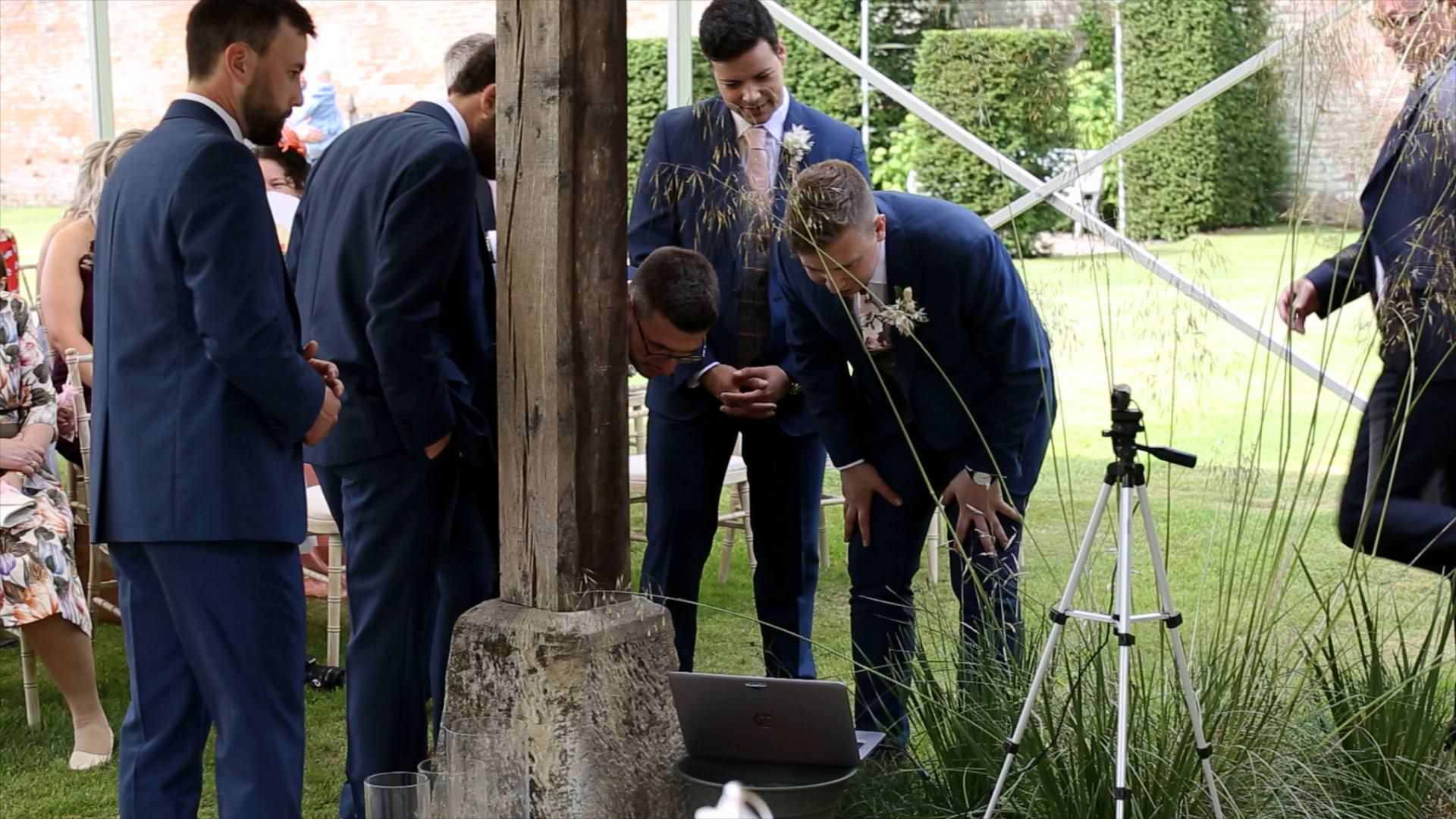 groomsman set up zoom link during outdoor ceremony