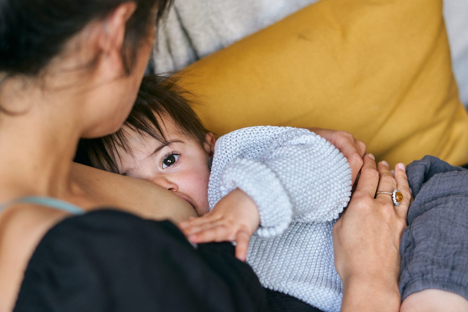candid photo of mum breastfeeding daughter at home
