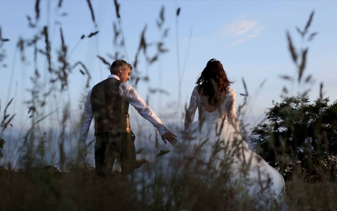 video of bride and groom walking through field