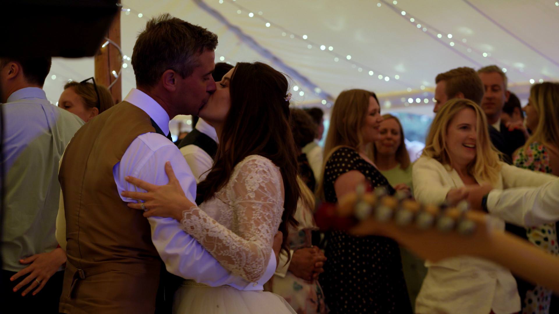 bride and groom kiss during evening tipi reception