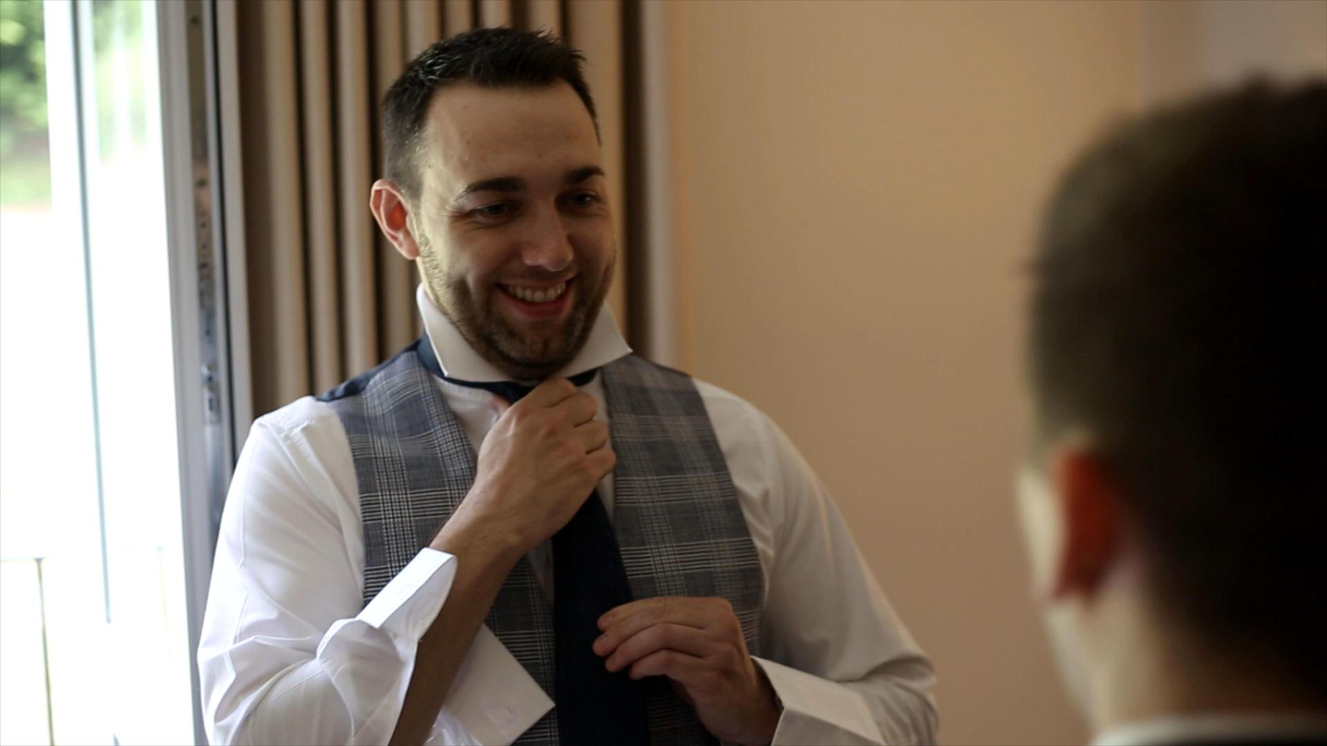 groom fixes his wedding tie
