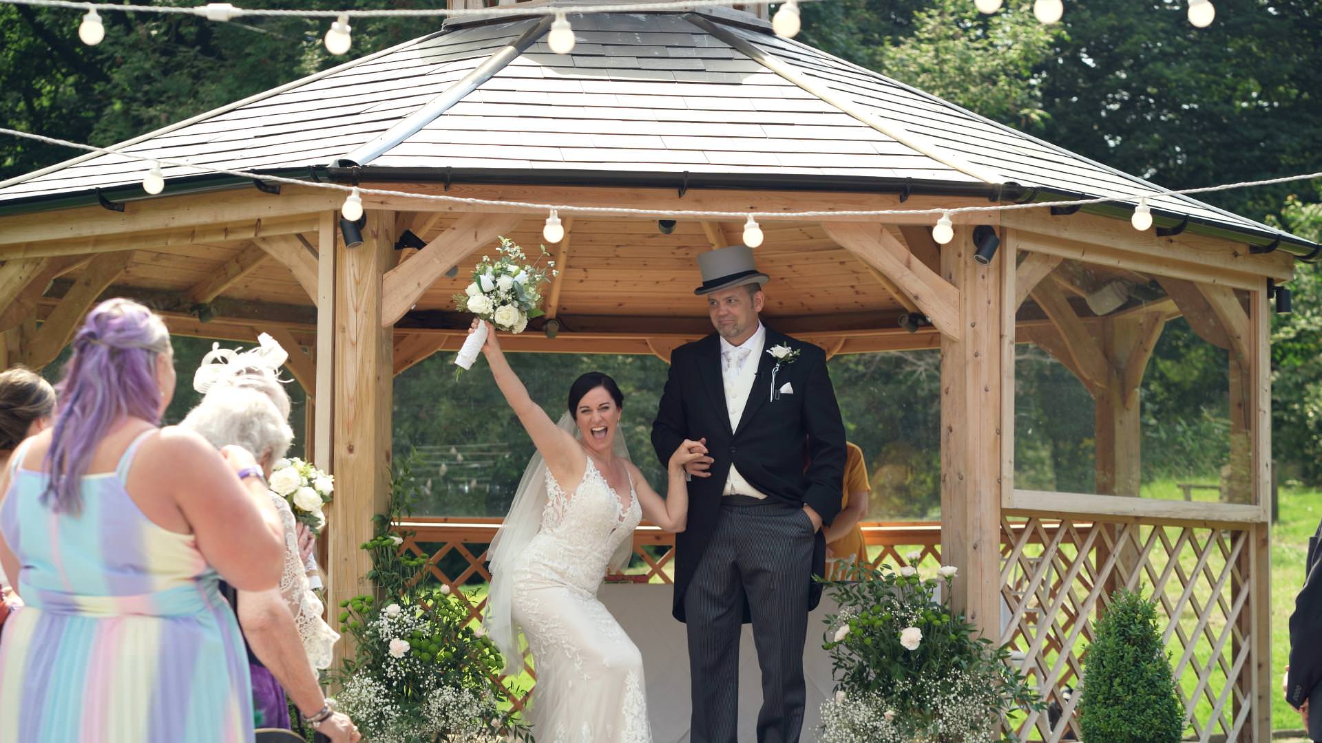 excited bride throws bouquet in the air after ceremony