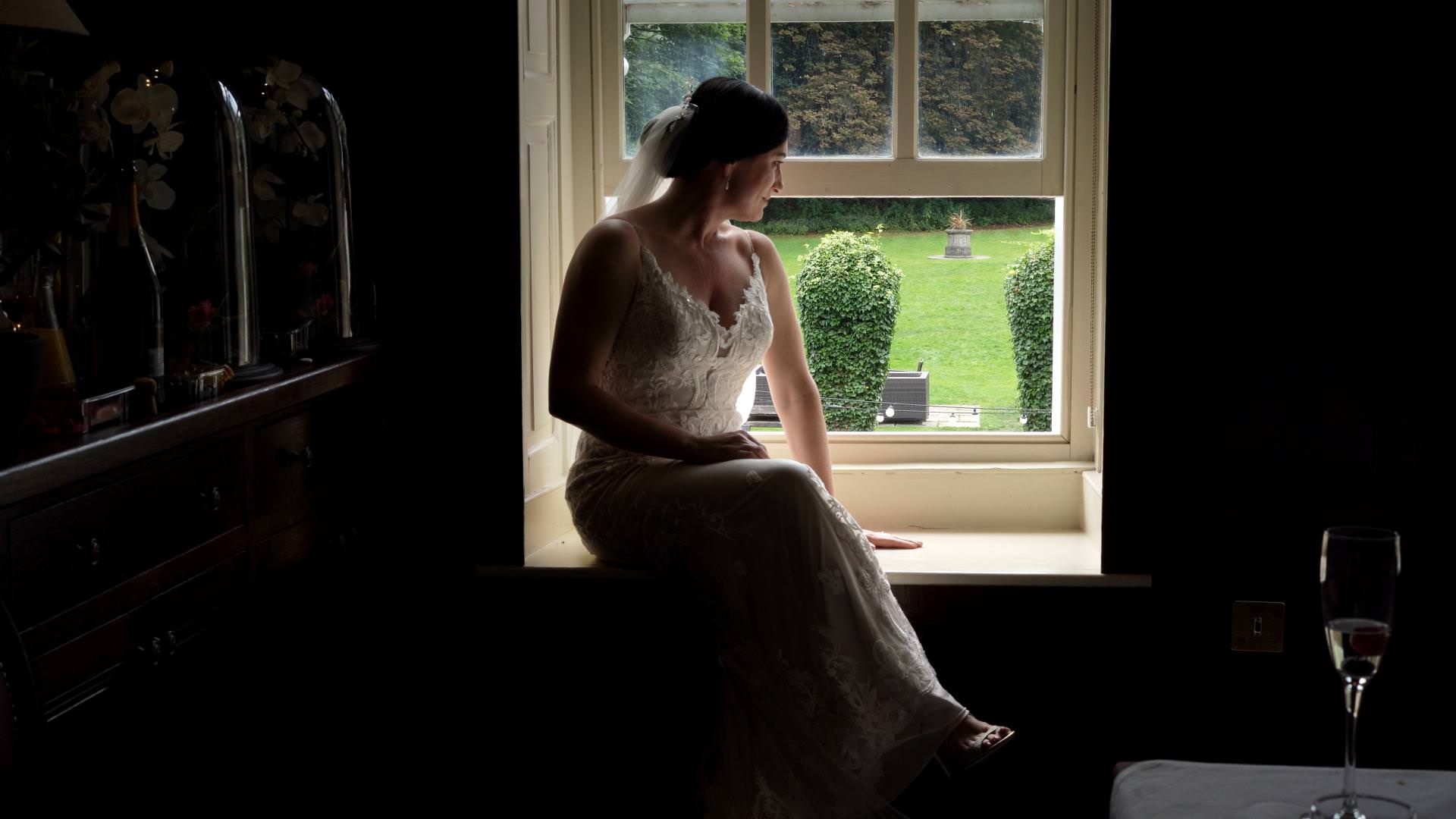 bride sits in window at Whitley Hall