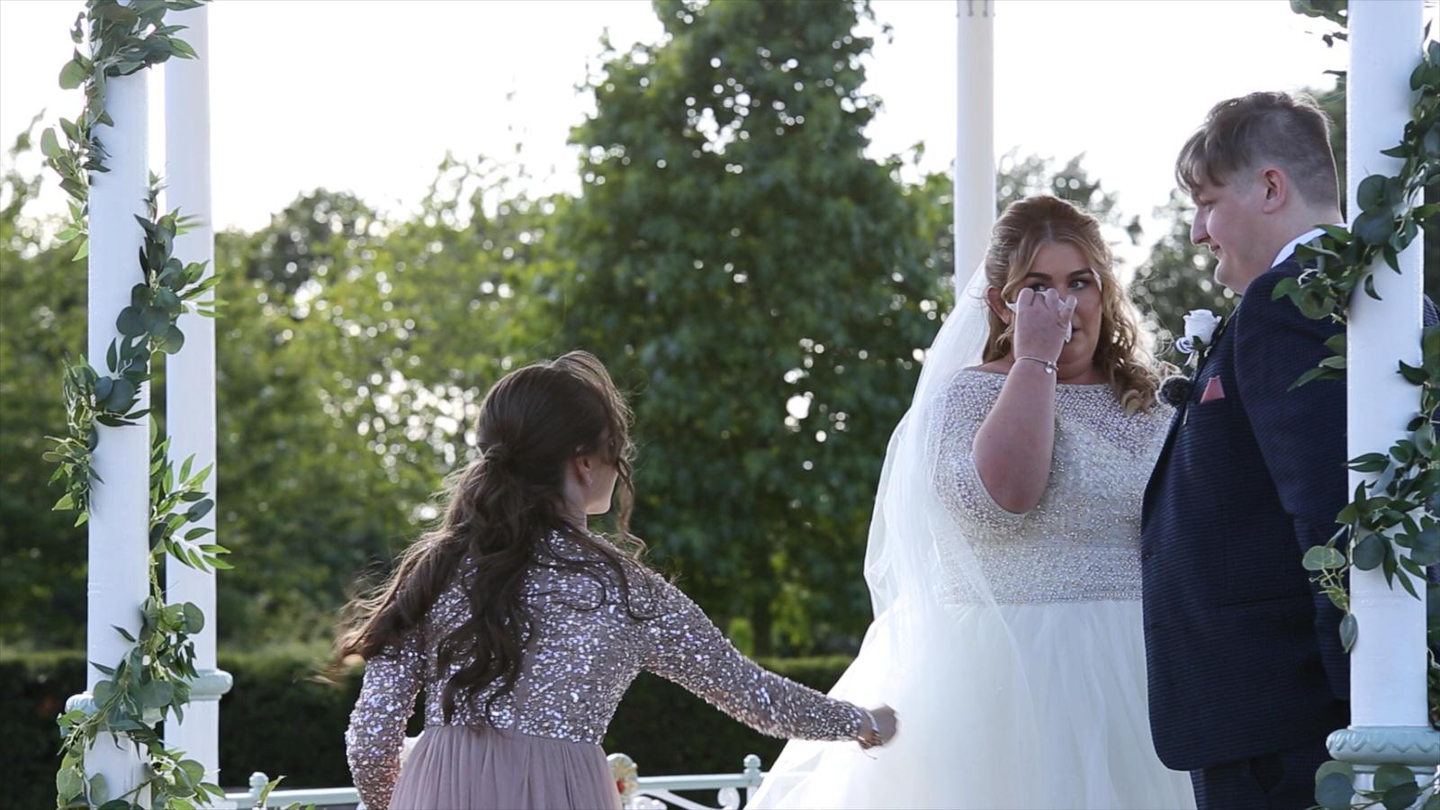 bride wipes tear away during outdoor ceremony at Isla Gladstone