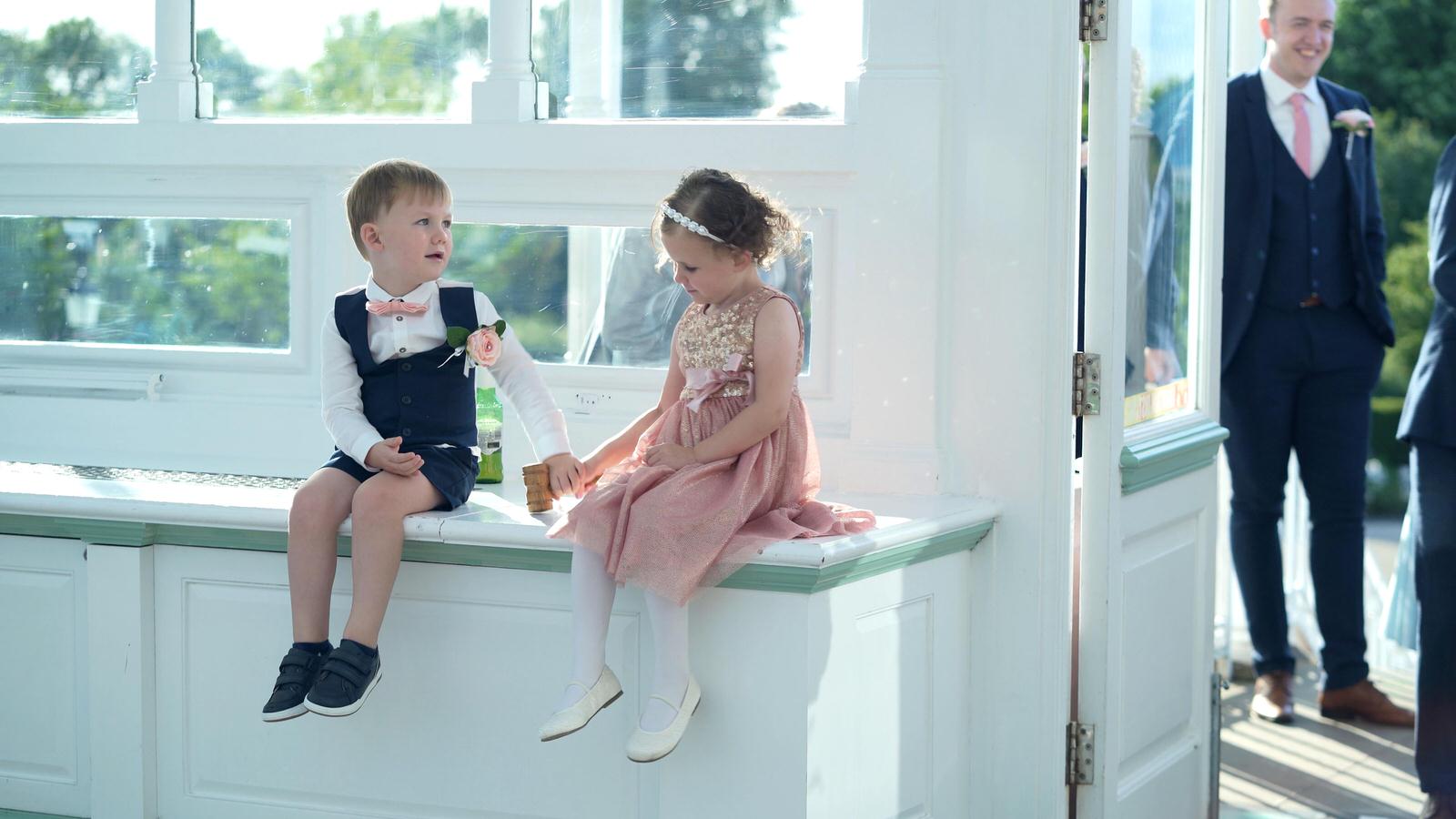 flower girl and pageboy sit on windowsill at isla gladstone