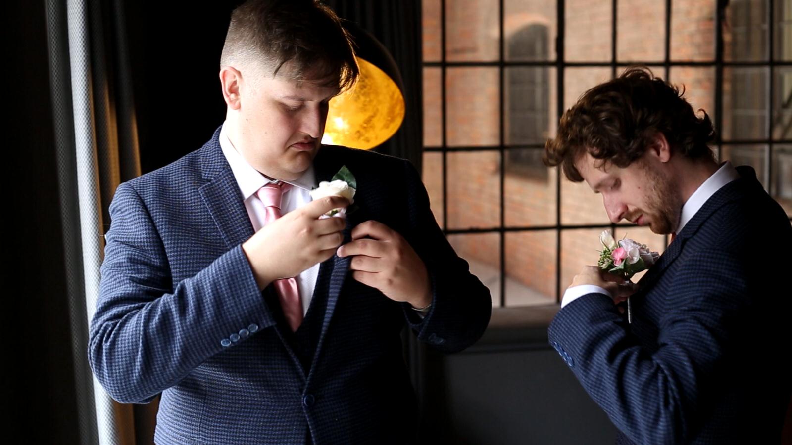 groom and best man struggle with buttonholes