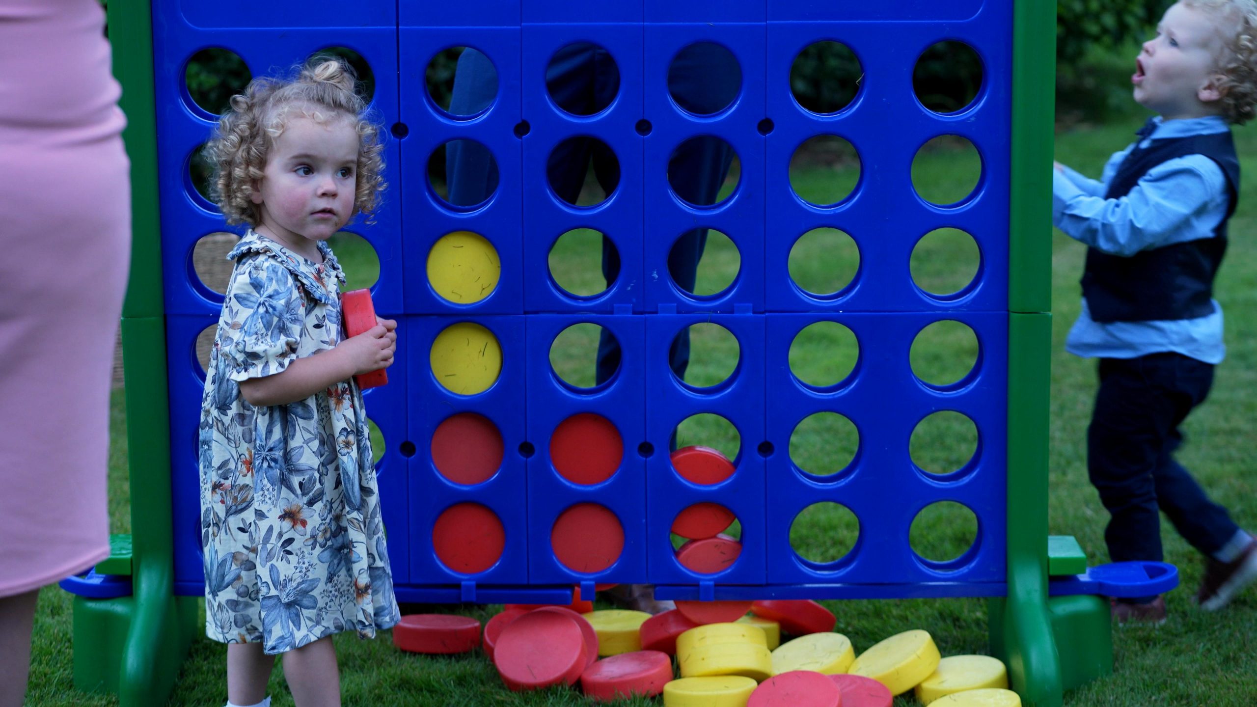 children play with large connect 4 garden game at wedding