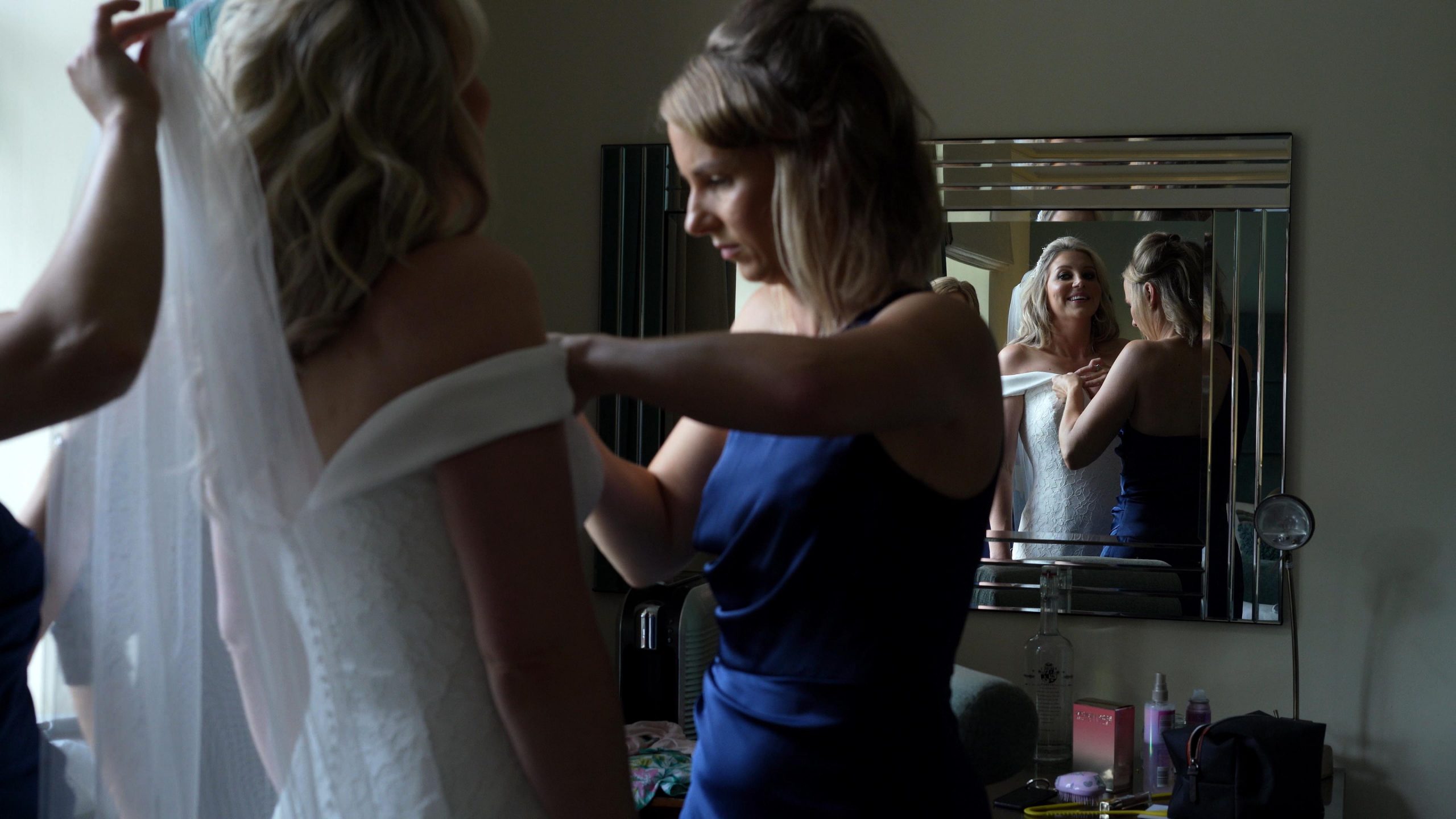 bridesmaids help bride in to dress at inglewood manor