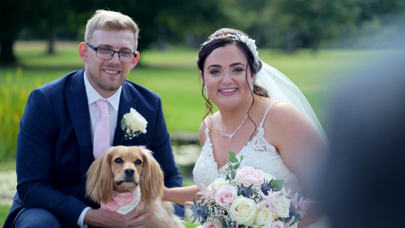 bride and groom pose for photos with dog